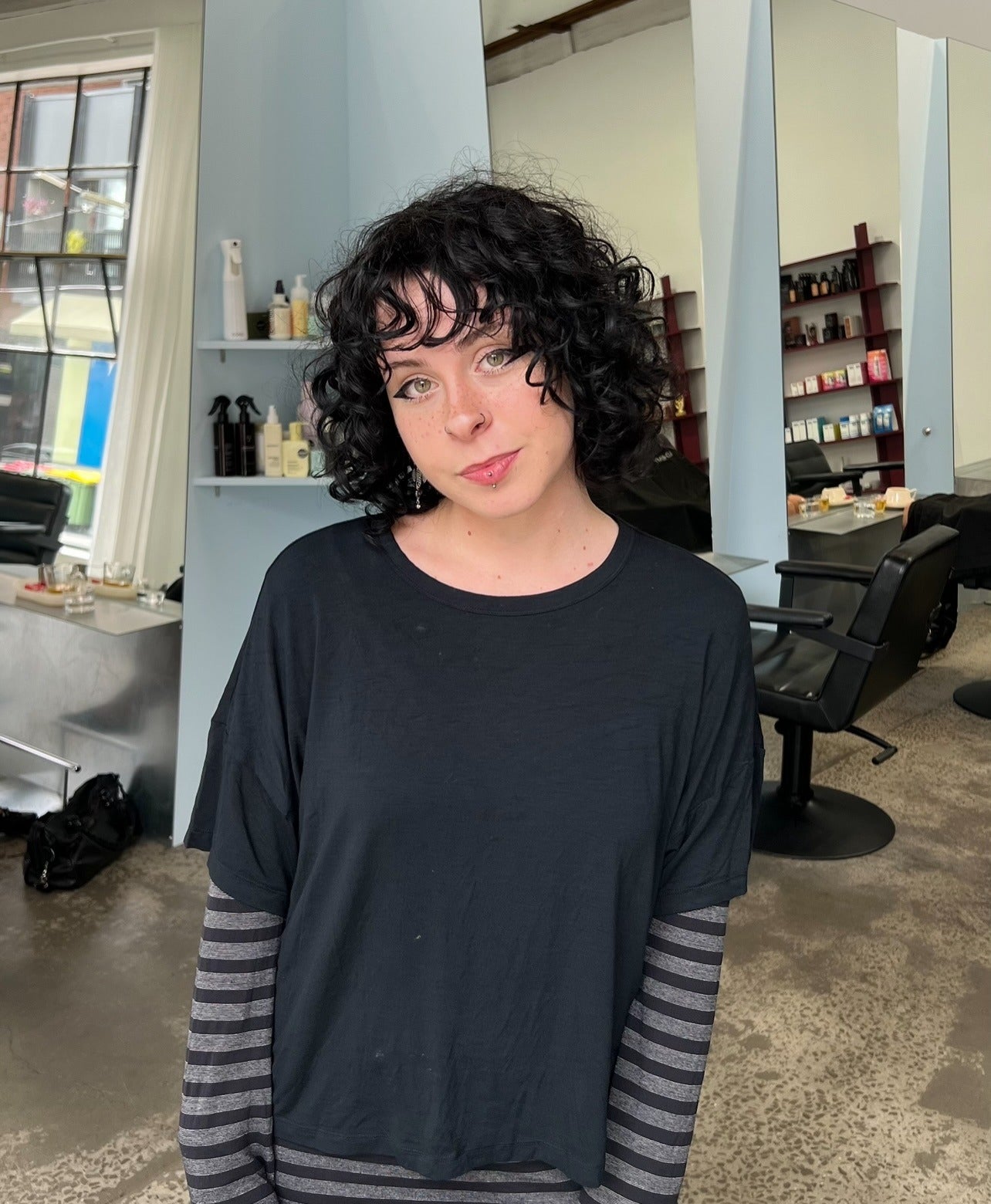 14. Tiefschwarzer lockiger Bob mit strukturiertem Pony (lockige Bob-Frisuren)