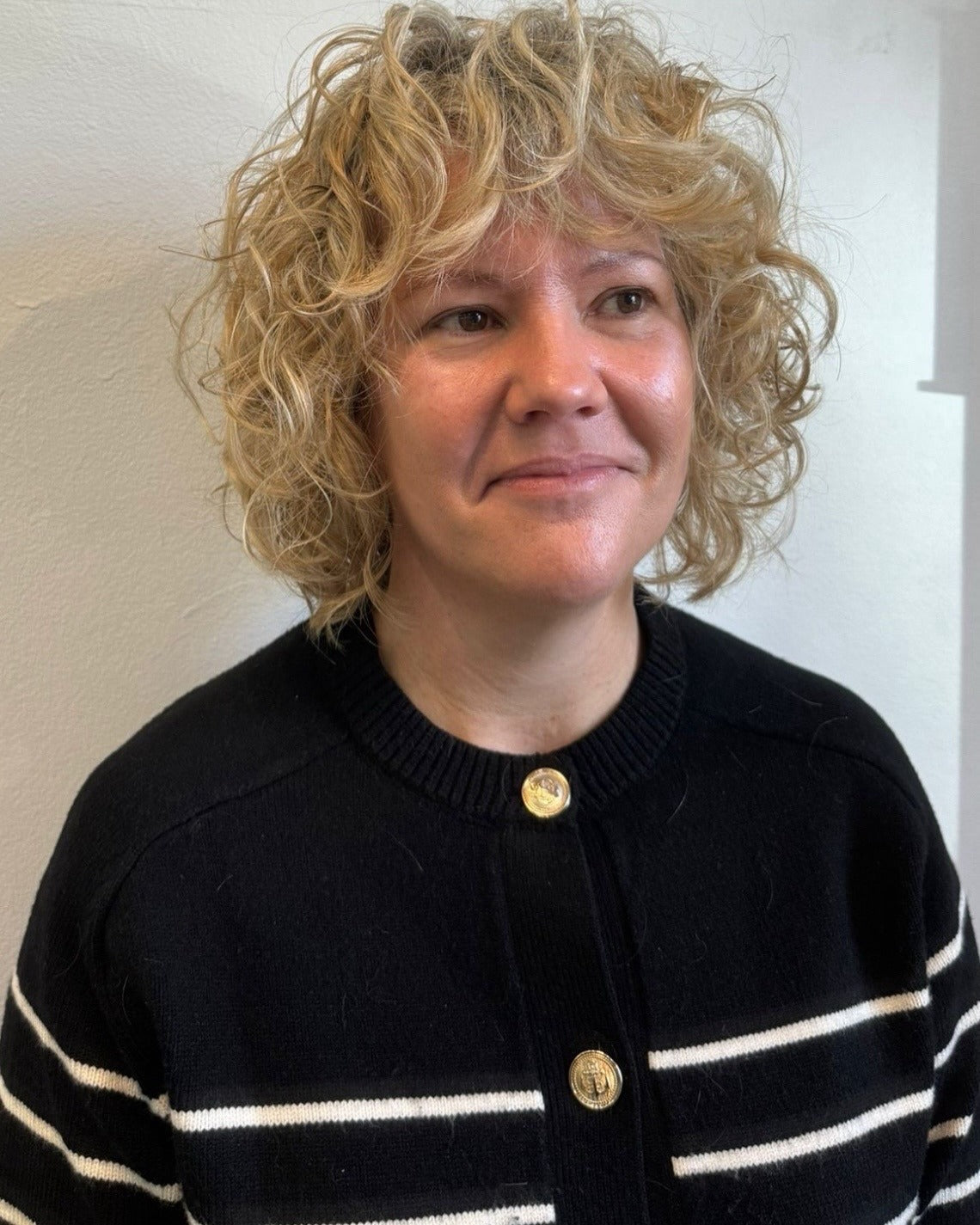 2. Goldblonder lockiger Bob mit strukturiertem Pony (lockige Bob-Frisuren)